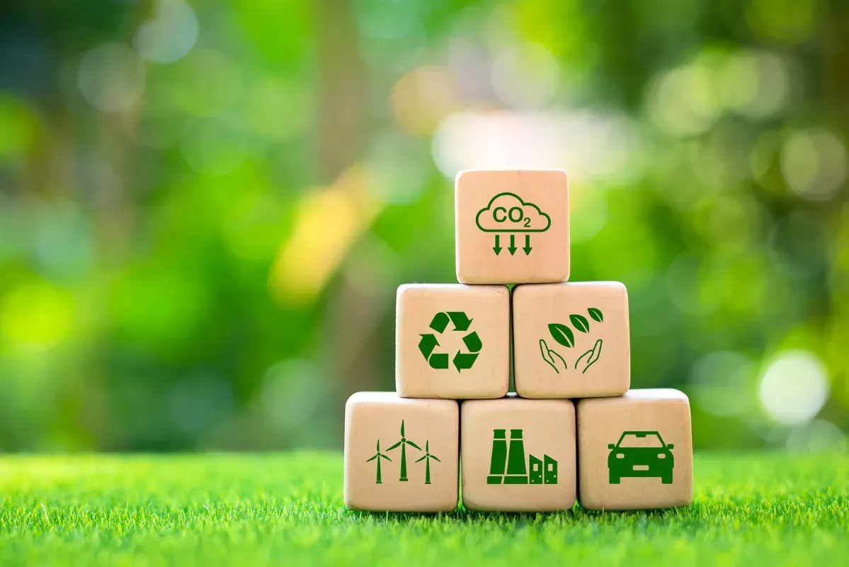 Drewniane klocki z ikonami zielonej energii na tle zieleni